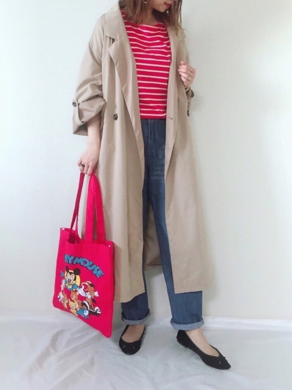 ベージュ系のトレンチコート、ブルー系のデニムパンツ、ブラック系のバレエシューズを着用したレディースの春コーディネートの1枚目の写真