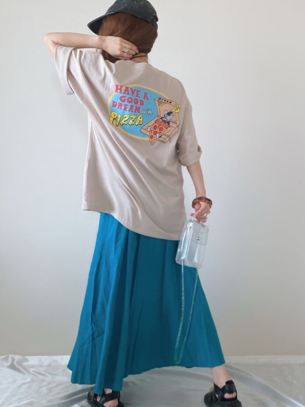 ベージュ系のTシャツ/カットソー、ブルー系のスカート、その他のショルダーバッグを着用したレディースの春コーディネートの1枚目の写真