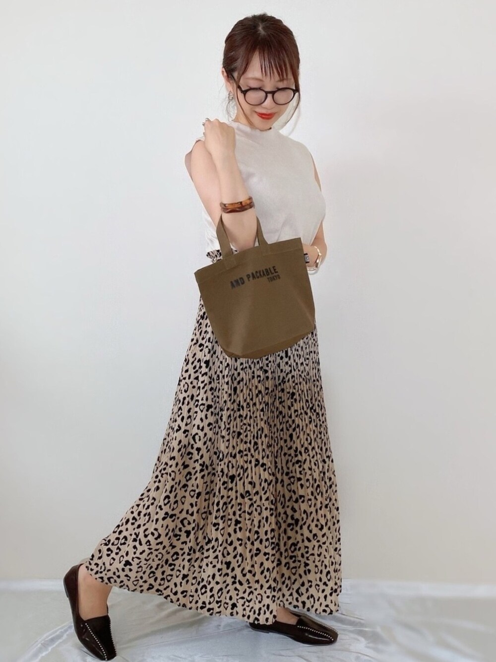 ブラウン系のローファー、ブラウン系のトートバッグ、ブラウン系のバングル/リストバンドを着用したレディースの秋コーディネートの1枚目の写真