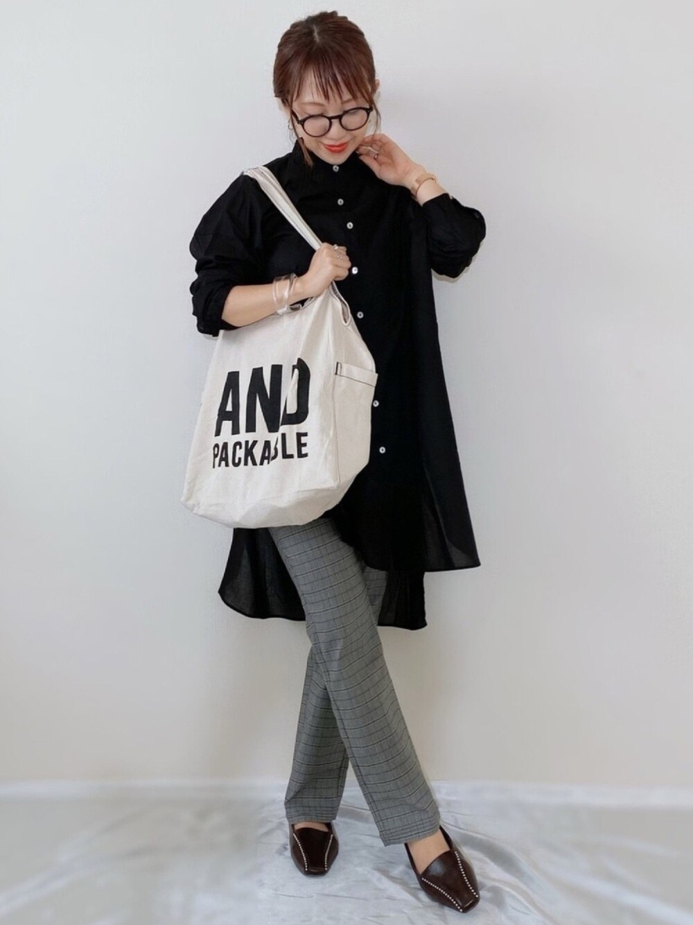 ブラック系のシャツ/ブラウス、ブラウン系のローファー、ホワイト系のトートバッグを着用したレディースの秋コーディネートの1枚目の写真