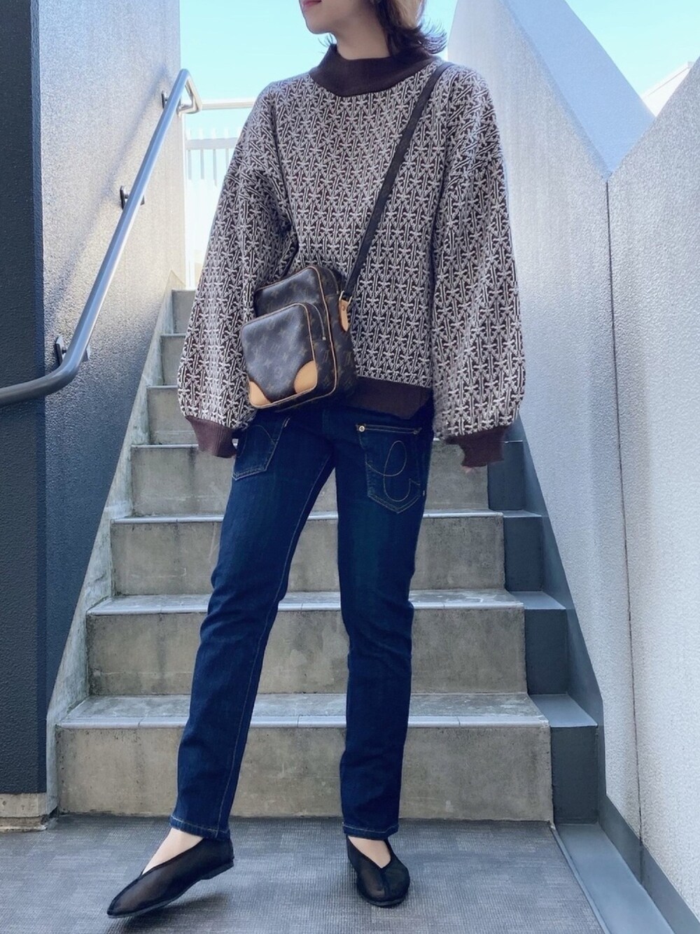 ブラウン系のニット/セーター、ブラック系のバレエシューズを着用したレディースの冬コーディネートの1枚目の写真