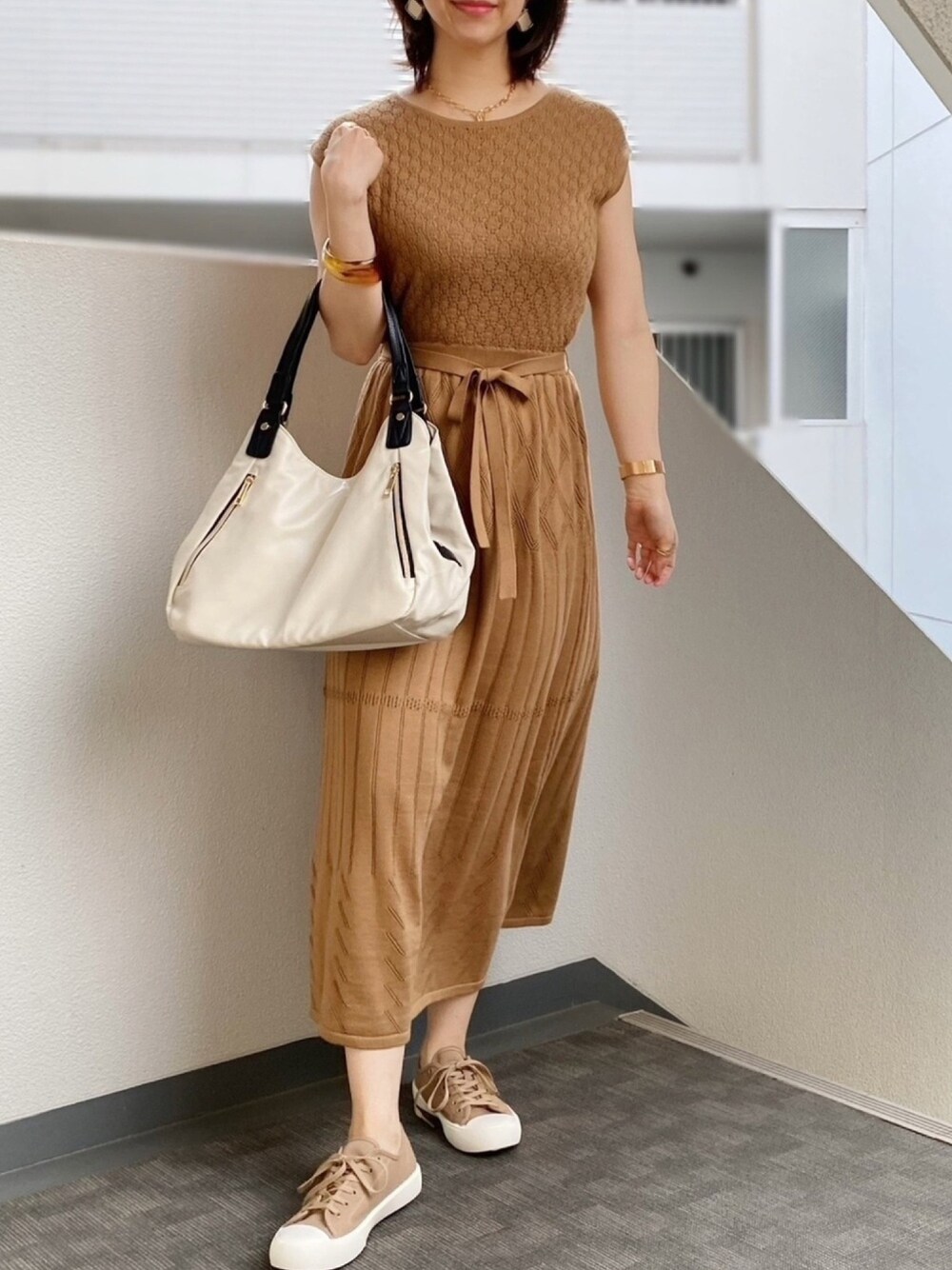 ベージュ系のワンピース、ベージュ系のバッグ、ベージュ系のスニーカーを着用したレディースの春コーディネートの1枚目の写真
