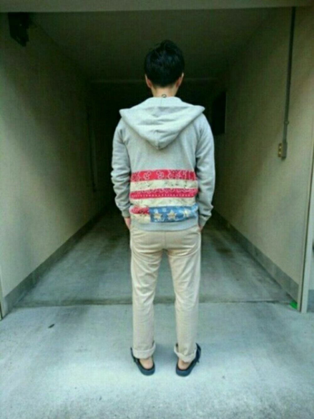 グレー系のパーカー、ベージュ系のチノパンツ、ブルー系のサンダルを着用したメンズの秋コーディネートの1枚目の写真