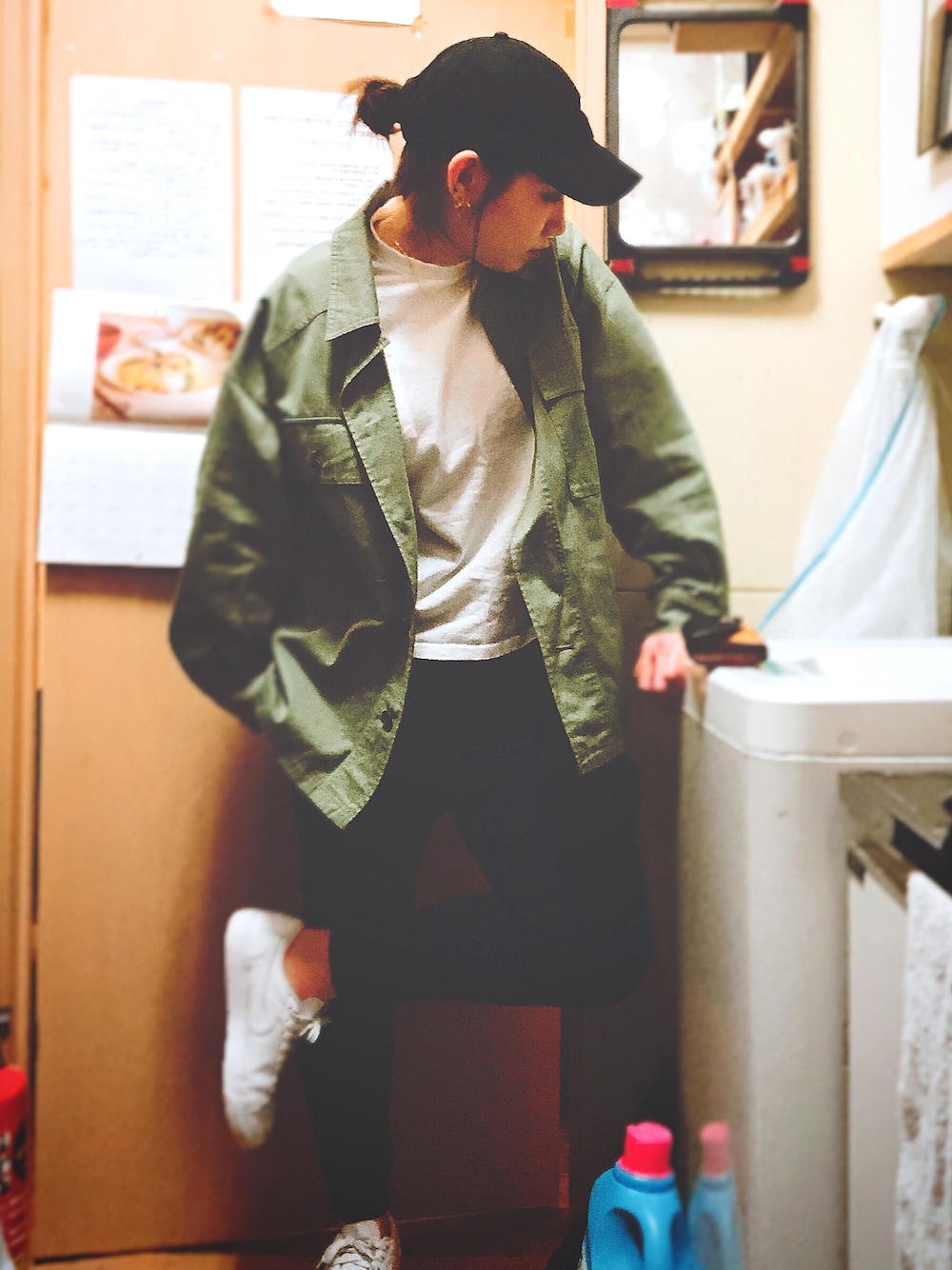 グリーン系のミリタリージャケット、ホワイト系のTシャツ/カットソー、ホワイト系のスニーカーを着用したレディースの春コーディネートの1枚目の写真