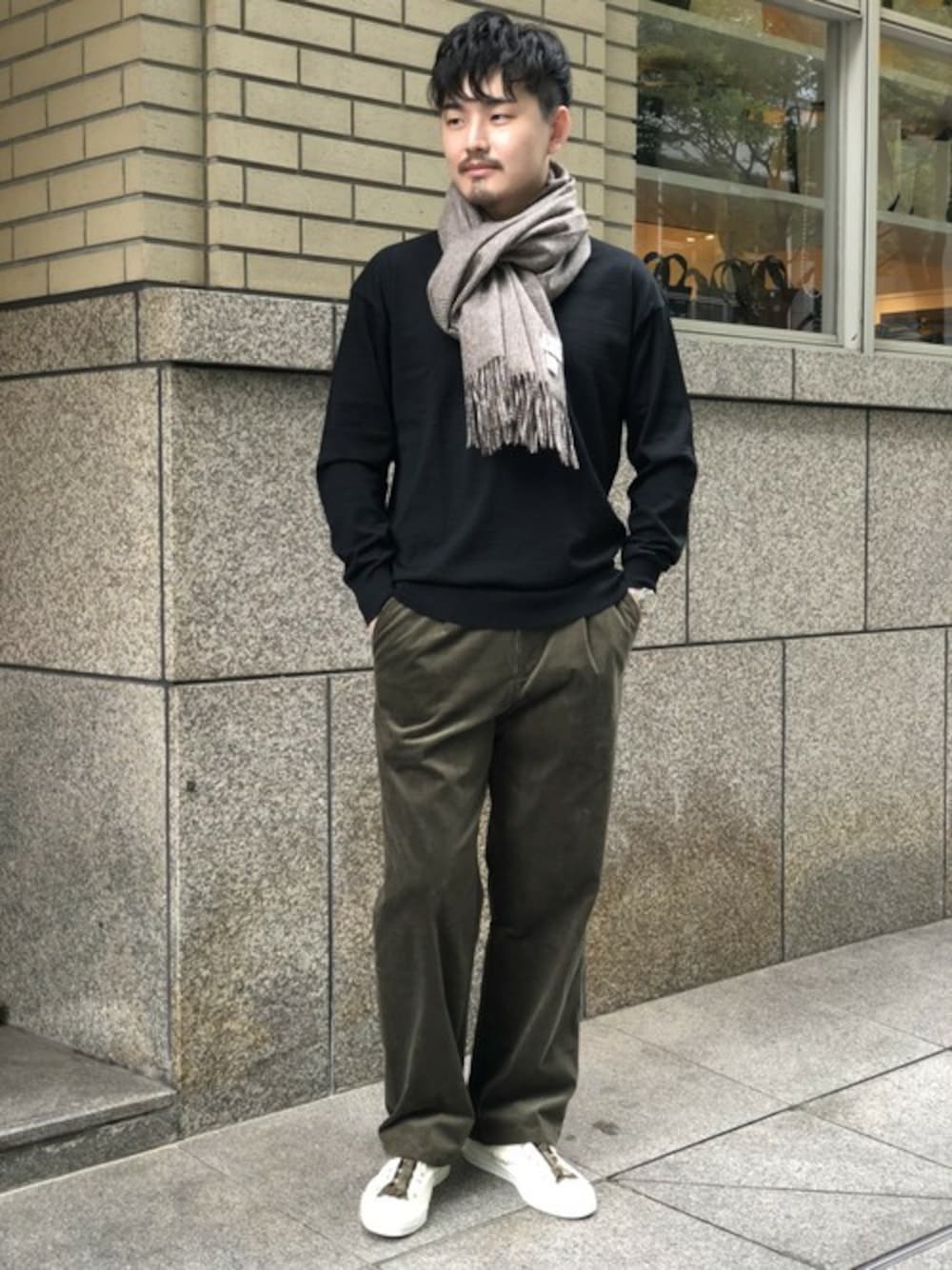 ブラック系のニット/セーター、グリーン系のその他パンツ、ホワイト系のスニーカーを着用したメンズの秋コーディネートの1枚目の写真