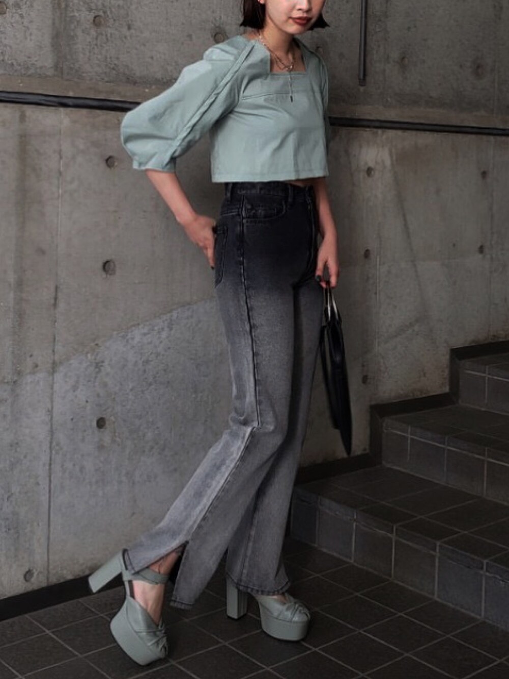 ブラック系のデニムパンツを着用したレディースの冬コーディネートの1枚目の写真