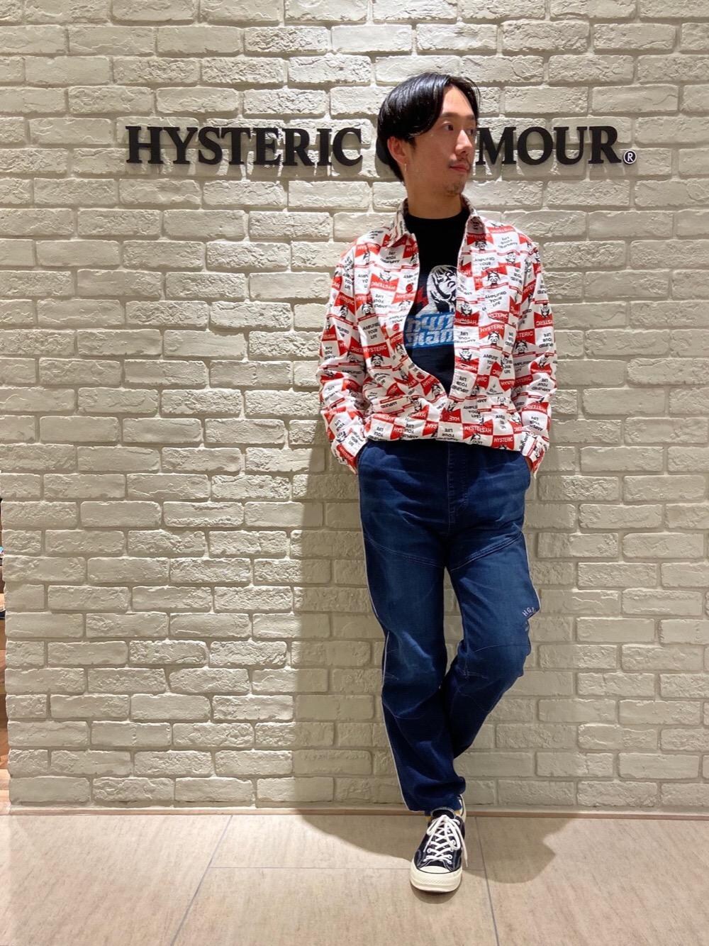 レッド系のカバーオール、ブラック系のTシャツ/カットソー、ブルー系のデニムパンツを着用したメンズの秋コーディネートの1枚目の写真