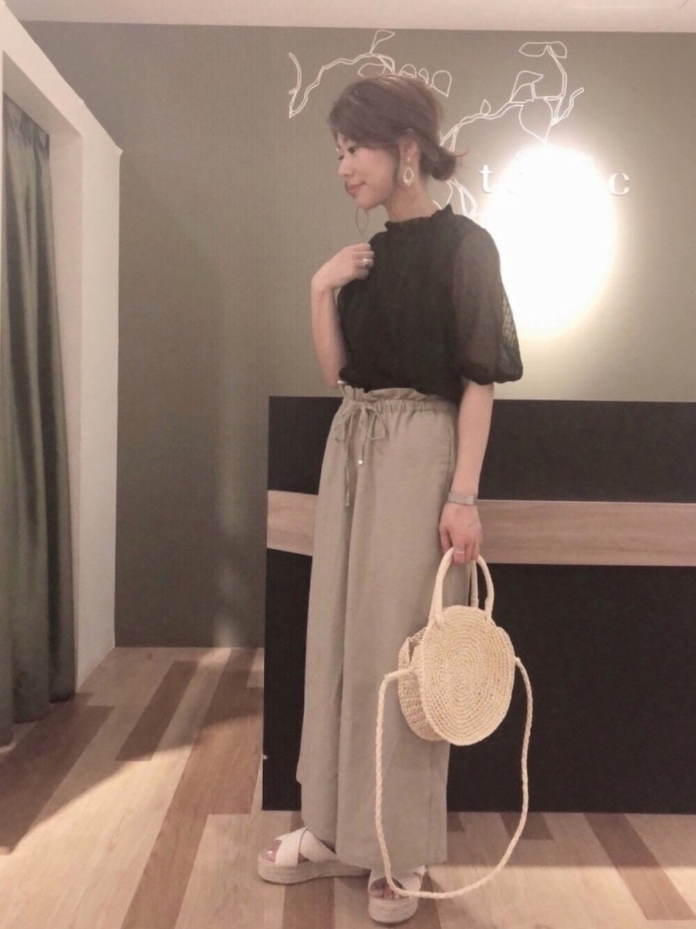 ホワイト系のサンダル、ベージュ系のその他パンツ、ブラック系のシャツ/ブラウスを着用したレディースの夏コーディネートの1枚目の写真