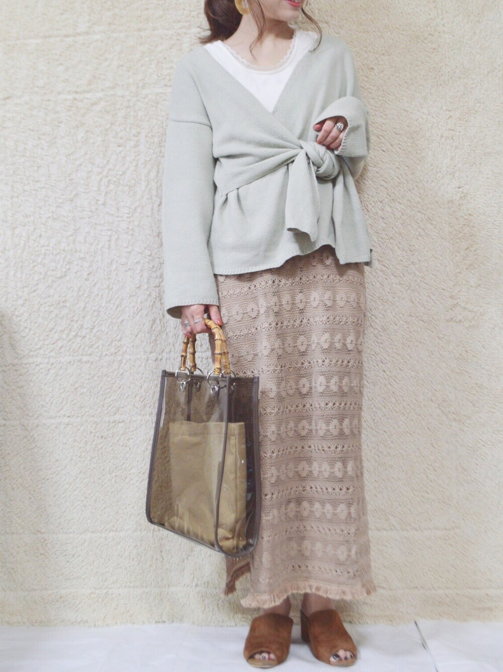 グリーン系のニット/セーターを着用したレディースの春コーディネートの1枚目の写真