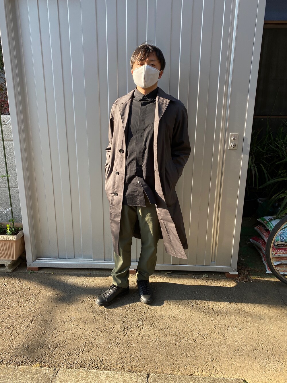 ブラック系のシャツ/ブラウス、ブラック系のスニーカー、グレー系のステンカラーコートを着用したメンズの冬コーディネートの1枚目の写真