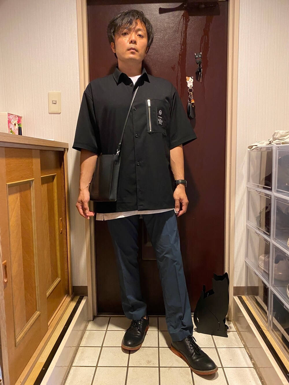 ブラック系のトップス、ホワイト系のTシャツ/カットソー、ブルー系のスラックスを着用したメンズの夏コーディネートの1枚目の写真