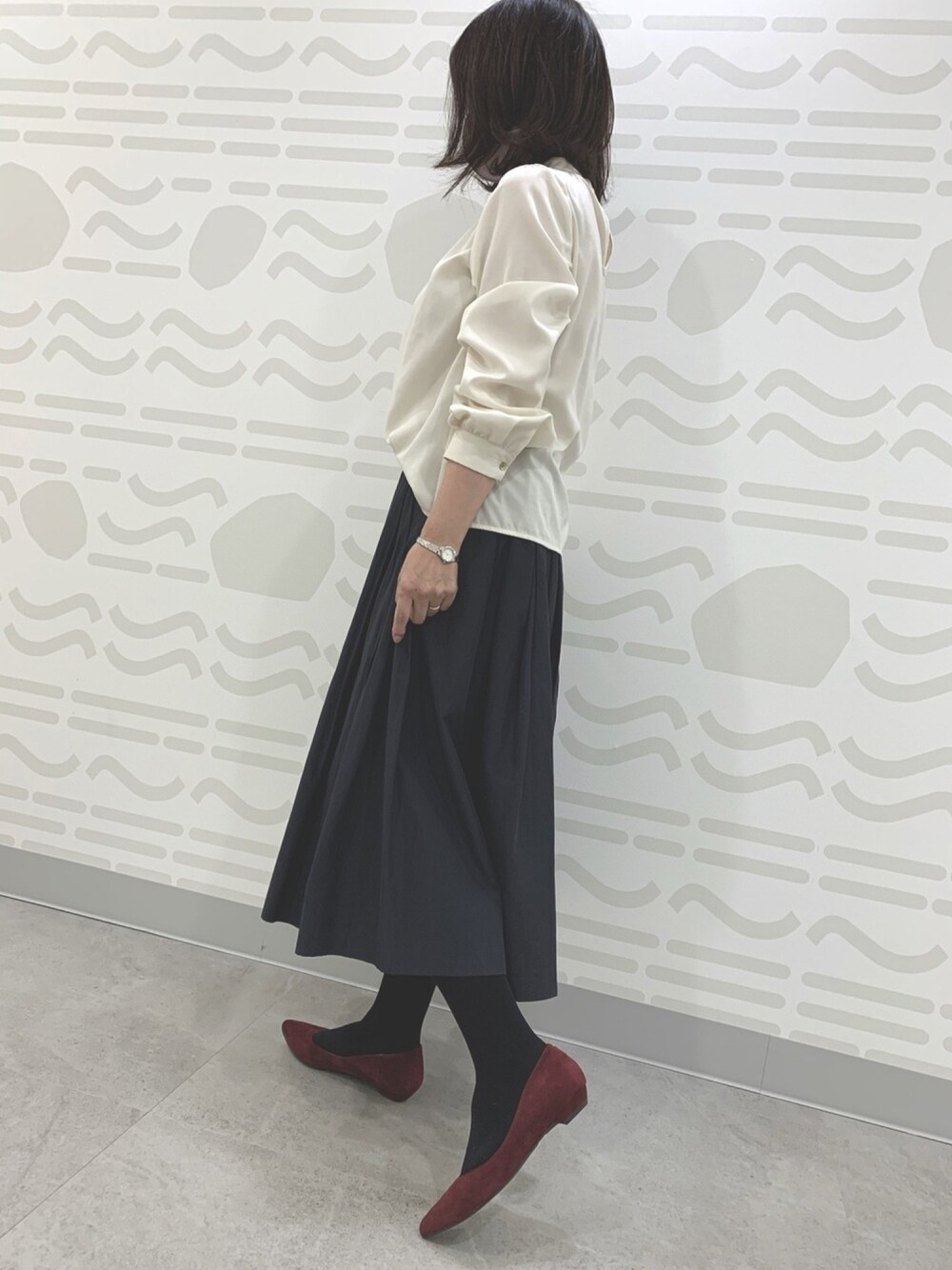 レッド系のパンプスを着用したレディースの冬コーディネートの1枚目の写真