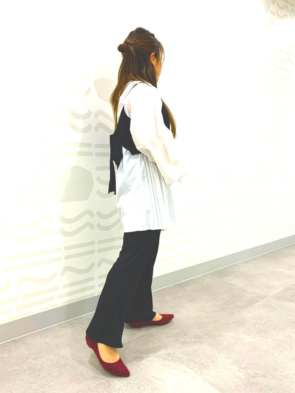 レッド系のパンプスを着用したレディースの冬コーディネートの1枚目の写真