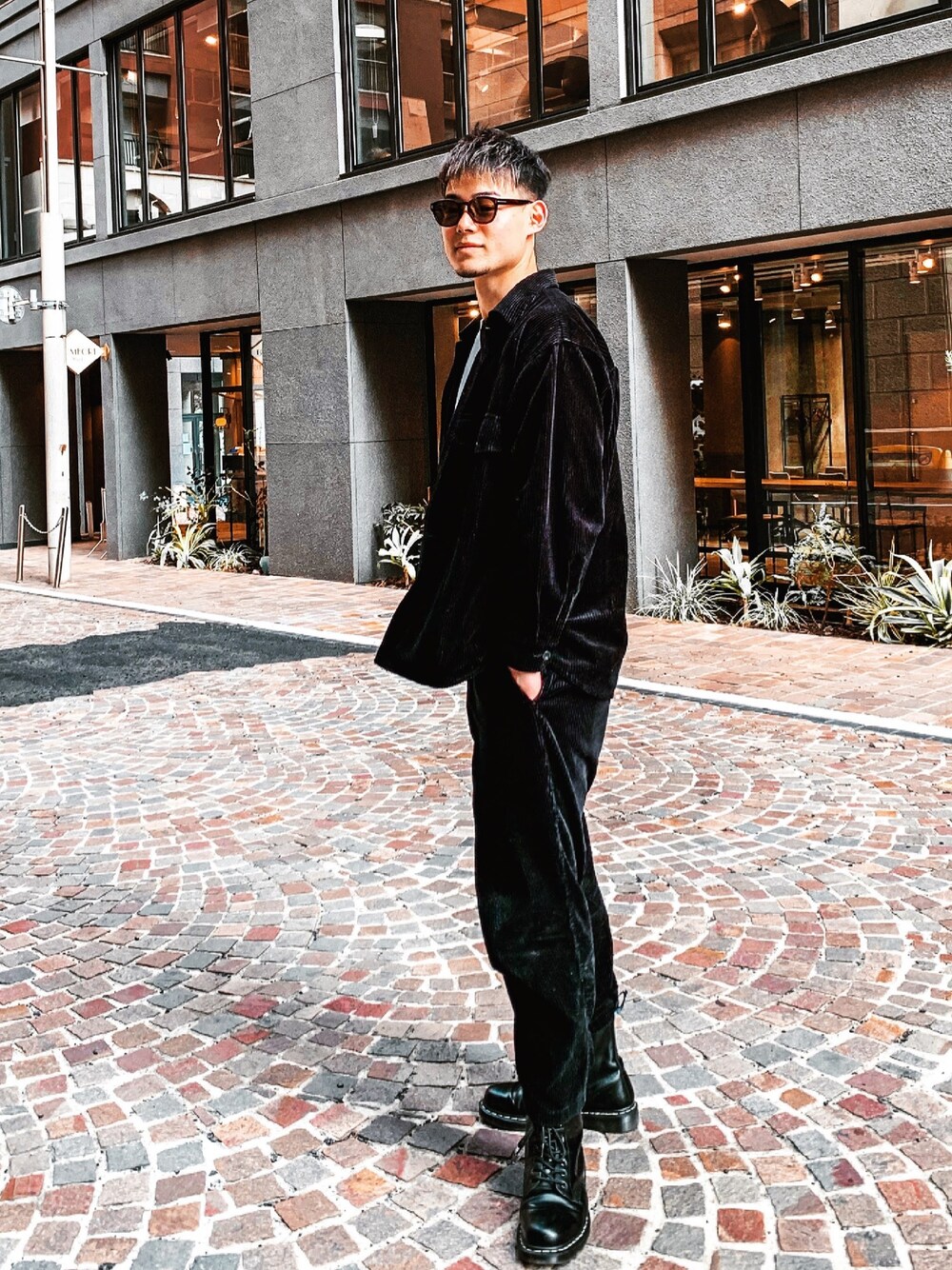 ブラック系のミリタリージャケット、ブラック系のカーゴパンツ、ブラック系のローファーを着用したメンズの春コーディネートの1枚目の写真