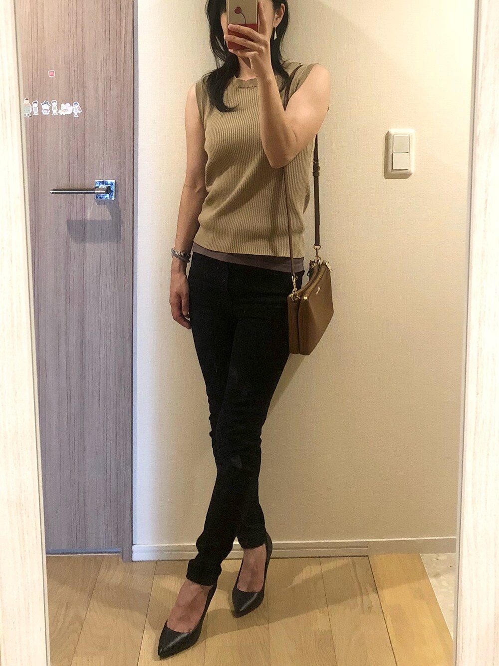 ブラック系のデニムパンツ、ブラウン系のニット/セーター、ブラック系のパンプスを着用したレディースの夏コーディネートの1枚目の写真