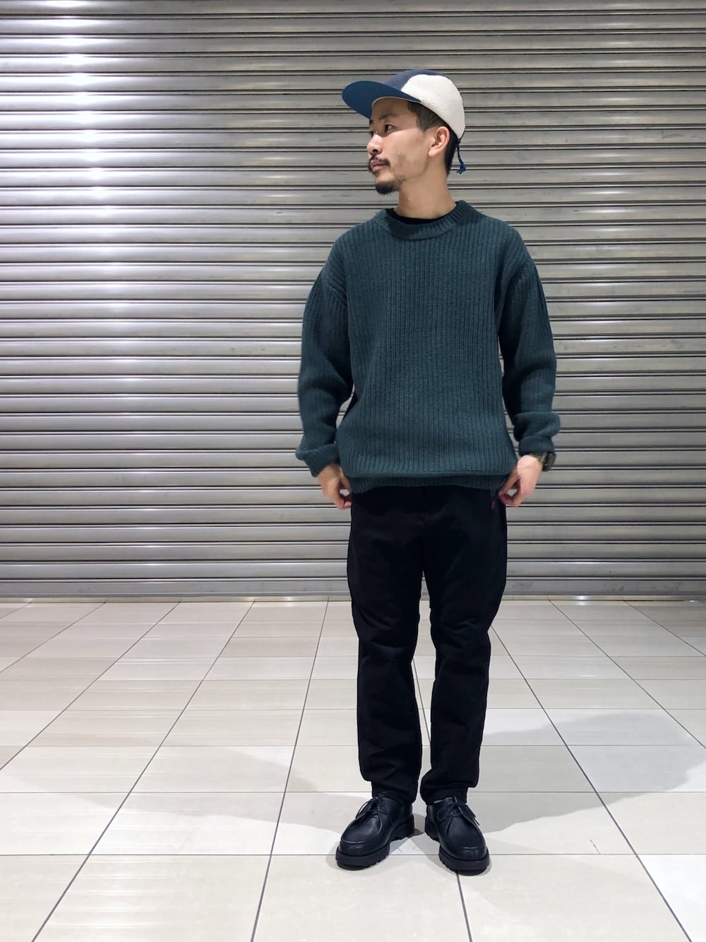 グリーン系のニット/セーター、ブラック系のその他パンツ、ブラック系のモカシン/デッキシューズを着用したメンズの秋コーディネートの1枚目の写真