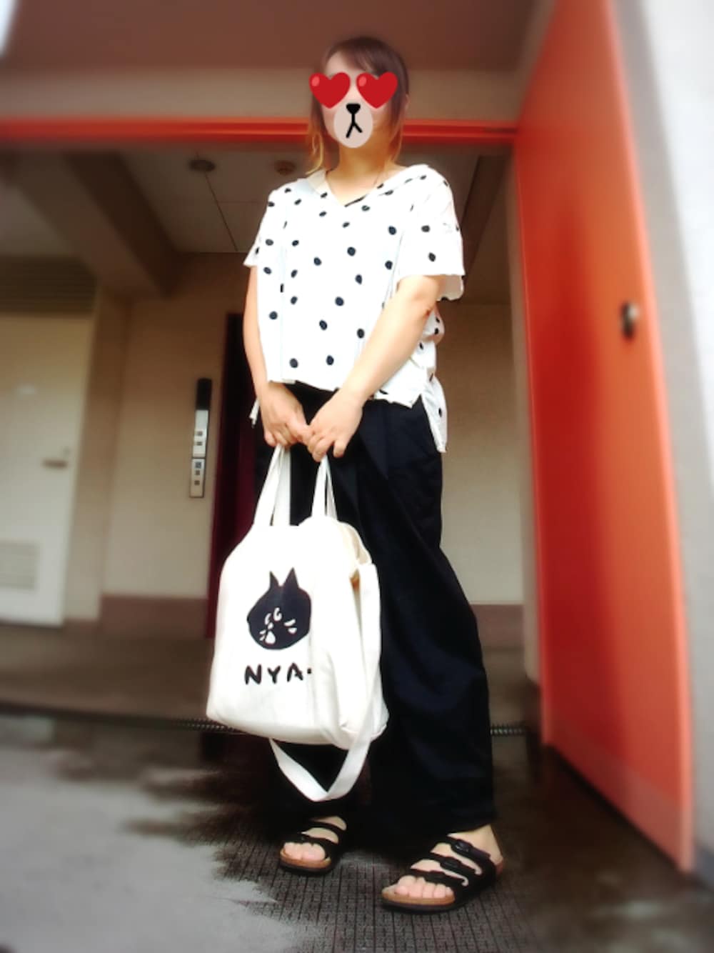 ブラック系のサンダル、ホワイト系のトートバッグ、ブラック系のチノパンツを着用したレディースの夏コーディネートの1枚目の写真