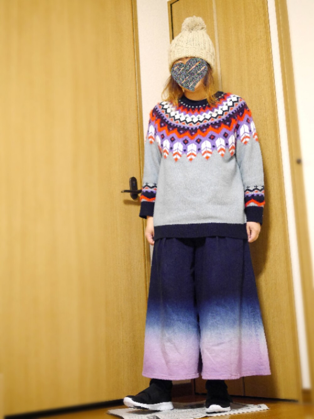 グレー系のニット/セーター、ブルー系のその他パンツ、ブラック系のスニーカーを着用したレディースの冬コーディネートの1枚目の写真