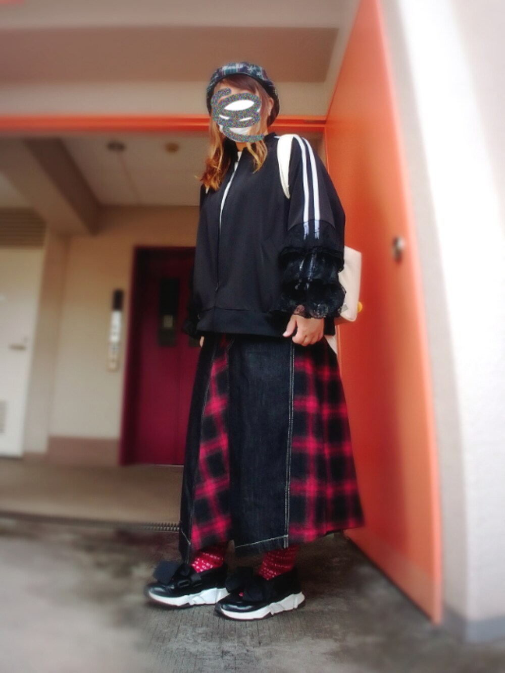 ブラック系のスカート、ブラック系のスニーカー、ホワイト系のバックパック/リュックを着用したレディースの秋コーディネートの1枚目の写真