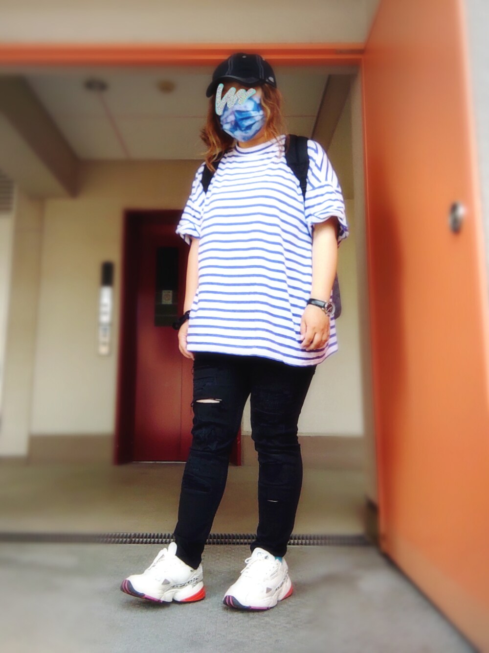 ブラック系のデニムパンツ、ブルー系のTシャツ/カットソー、ホワイト系のスニーカーを着用したレディースの春コーディネートの1枚目の写真