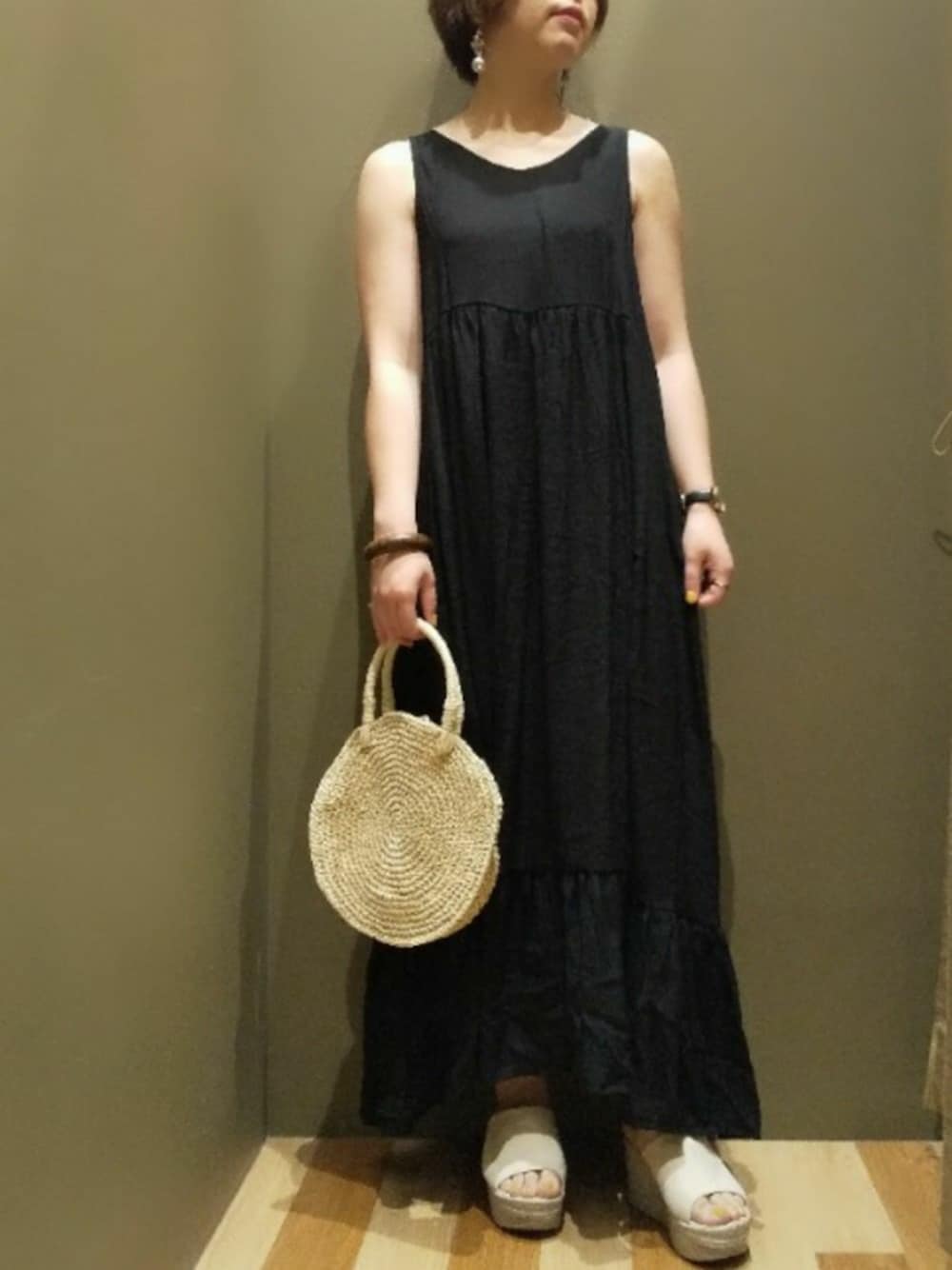 ブラック系のワンピース、ベージュ系のショルダーバッグ、ベージュ系のサンダルを着用したレディースの夏コーディネートの1枚目の写真