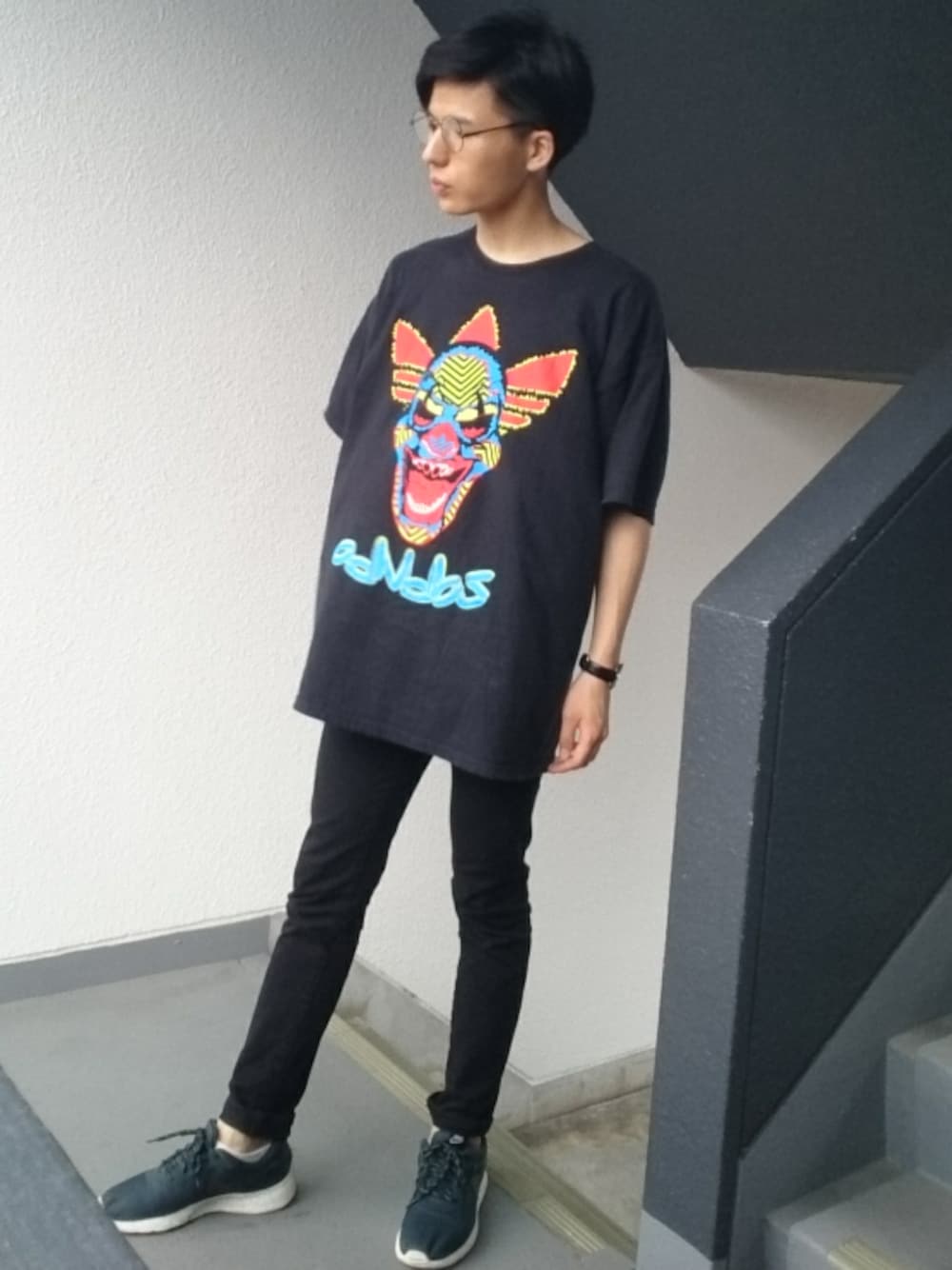 ブラック系のTシャツ/カットソー、ブルー系のデニムパンツ、ブラック系のスニーカーを着用したメンズの夏コーディネートの1枚目の写真