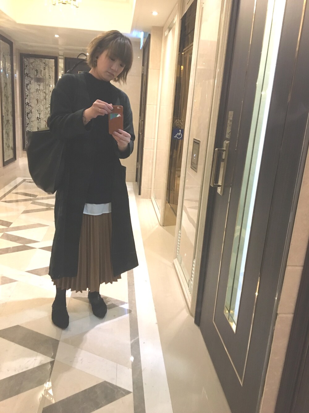 「オトナカジュアル、オトナ女子、オフィススタイル、オフィスカジュアル、プリーツスカート、ロングコート、大人カジュアル、レイヤードスタイル」｜「ANEMONEのアイテム（トートバッグ、ブラック系）」を使った、𝓈𝒽𝒶𝓃𝒾𝒸𝑒さん（レディース・165cm）の冬コーディネートの1枚目の写真