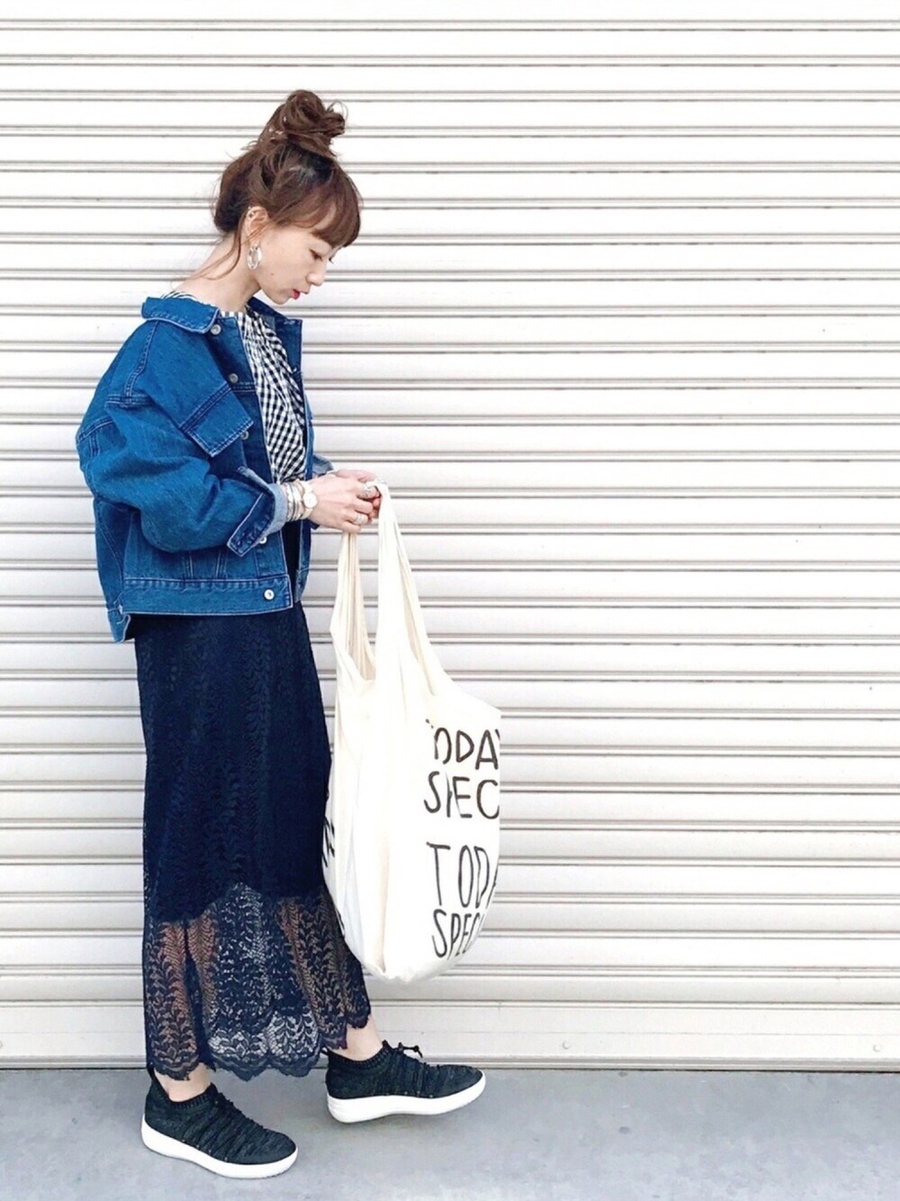 ブラック系のシャツ/ブラウス、ブルー系のデニムジャケット、ブルー系のスカートを着用したレディースの春コーディネートの1枚目の写真