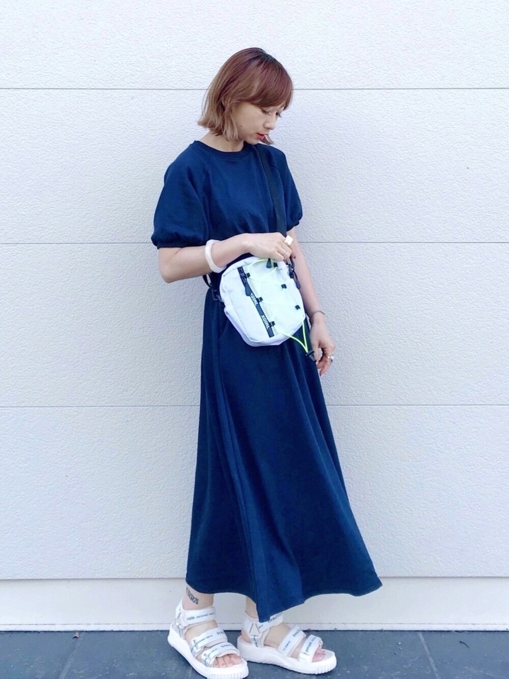 ブルー系のワンピース、ホワイト系のショルダーバッグ、ホワイト系のサンダルを着用したレディースの夏コーディネートの1枚目の写真
