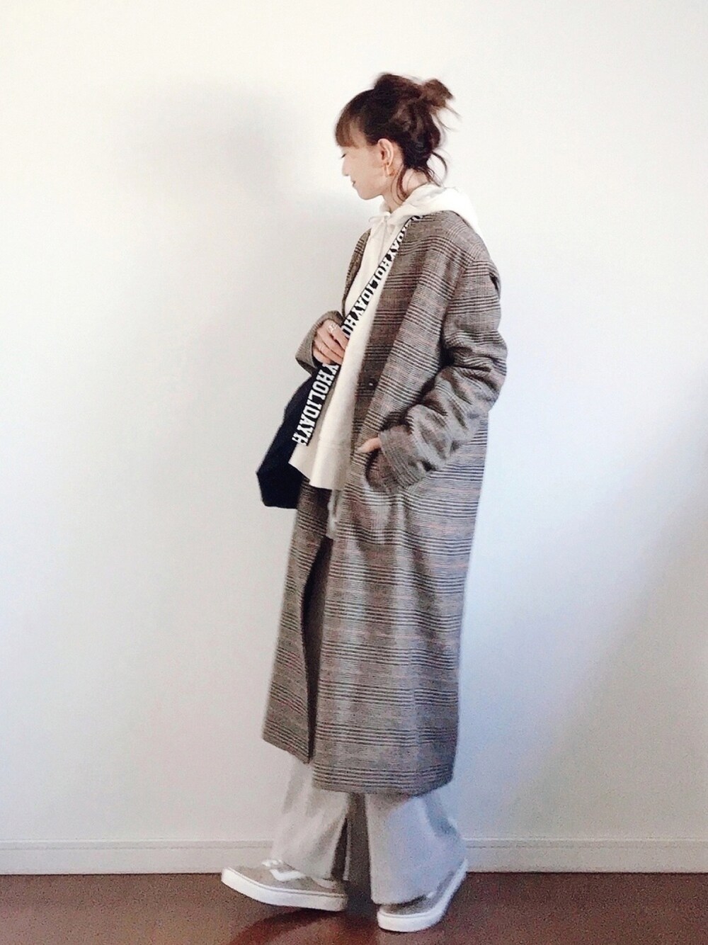 ベージュ系のノーカラーコート、ベージュ系のパーカー、ブラック系のショルダーバッグを着用したレディースの秋コーディネートの1枚目の写真