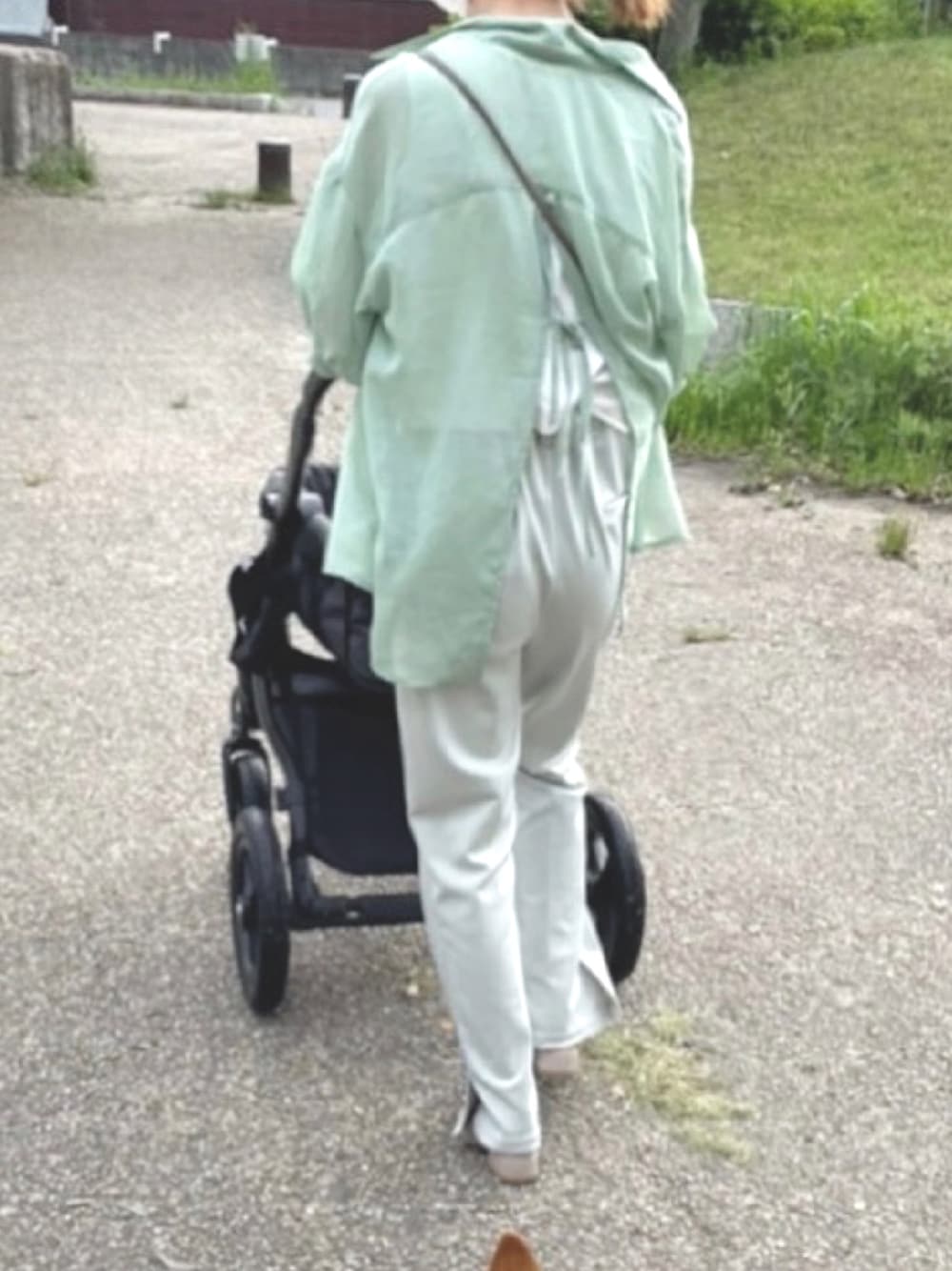 グリーン系のトップス、グリーン系のパンツ、ベージュ系のサンダルを着用したレディースの春コーディネートの1枚目の写真