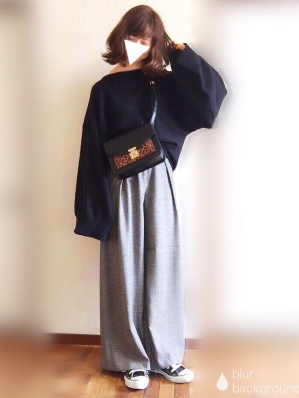 ブラック系のニット/セーター、グレー系のパンツ、ブラック系のショルダーバッグを着用したレディースの秋コーディネートの1枚目の写真