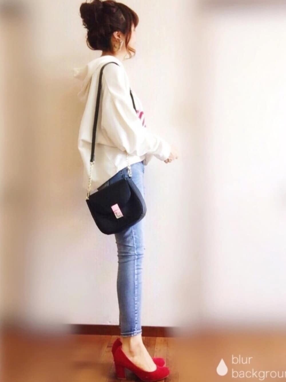 ホワイト系のパーカー、ブルー系のデニムパンツ、ブラック系のショルダーバッグを着用したレディースの秋コーディネートの1枚目の写真