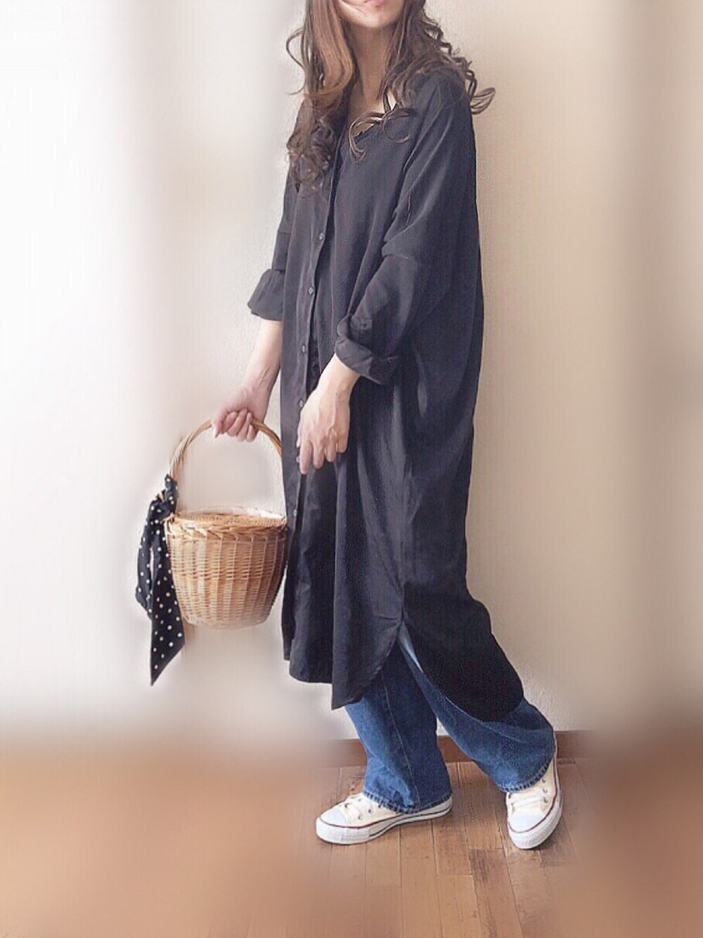 ブラック系のシャツワンピース、ブルー系のかごバッグ、ホワイト系のスニーカーを着用したレディースの春コーディネートの1枚目の写真