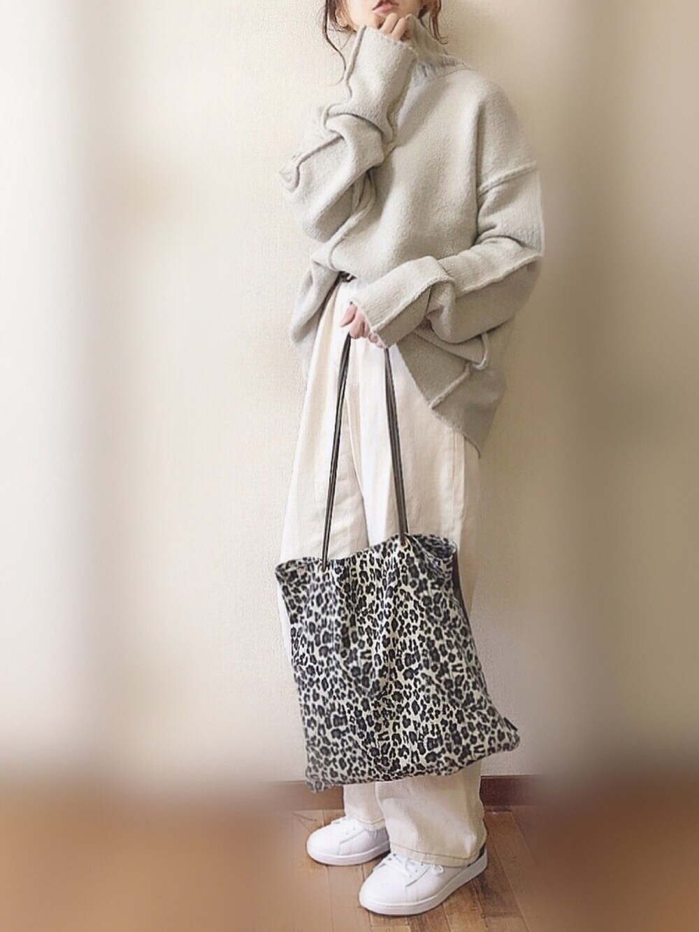 グレー系のニット/セーター、ホワイト系のデニムパンツ、ホワイト系のスニーカーを着用したレディースの冬コーディネートの1枚目の写真