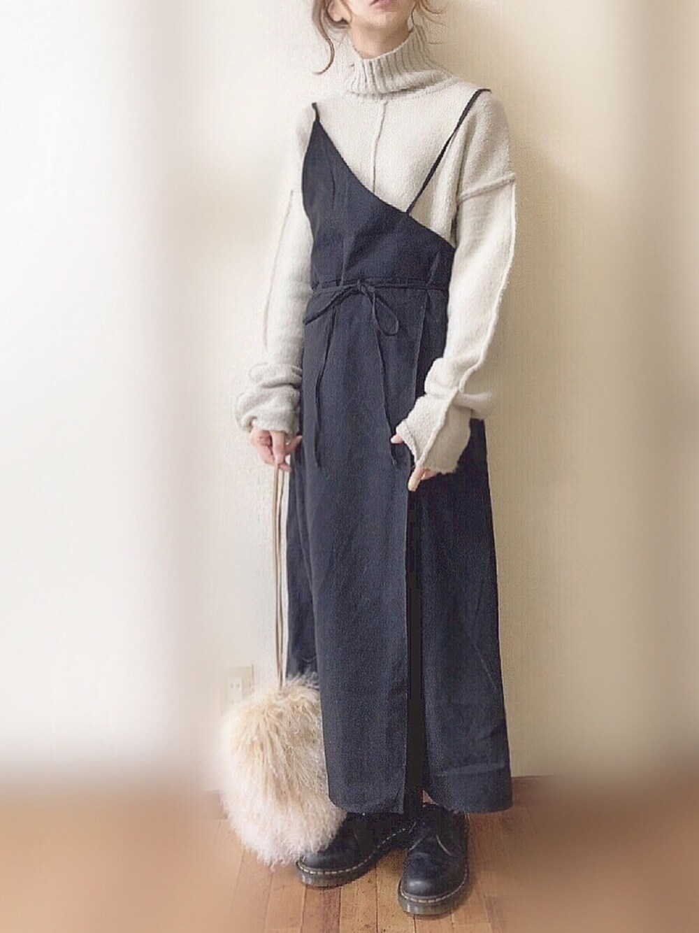 ブラック系のワンピース、グレー系のニット/セーター、ブラック系のブーツを着用したレディースの冬コーディネートの1枚目の写真