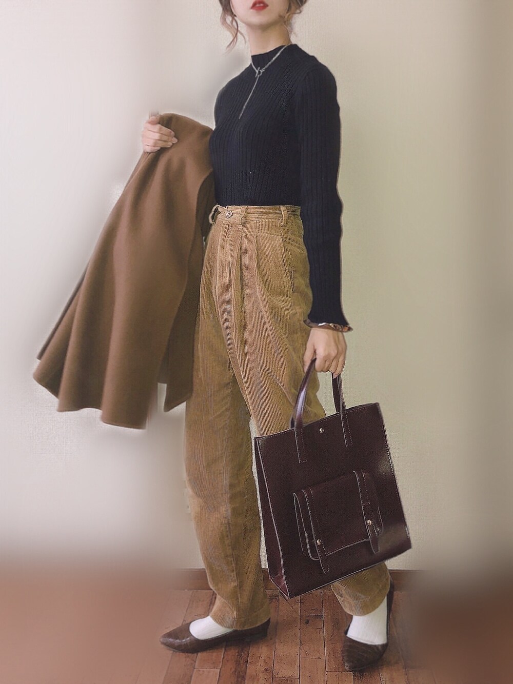 ブラック系のニット/セーター、ベージュ系のその他パンツ、ホワイト系のパンプスを着用したレディースの冬コーディネートの1枚目の写真