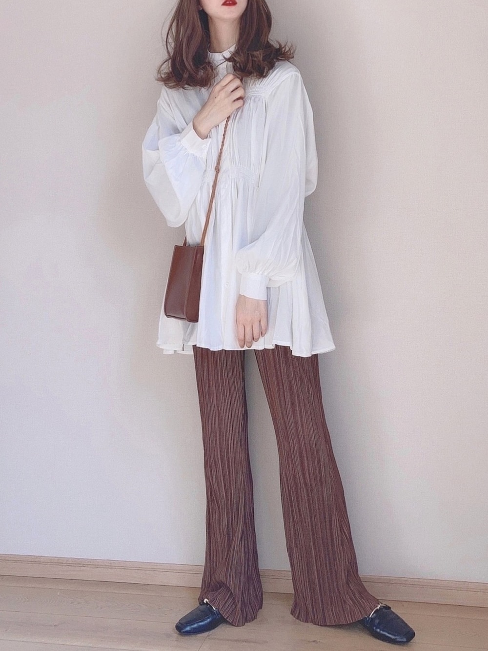 ホワイト系のチュニック、ブラウン系のその他パンツ、ブラック系のローファーを着用したレディースの冬コーディネートの1枚目の写真