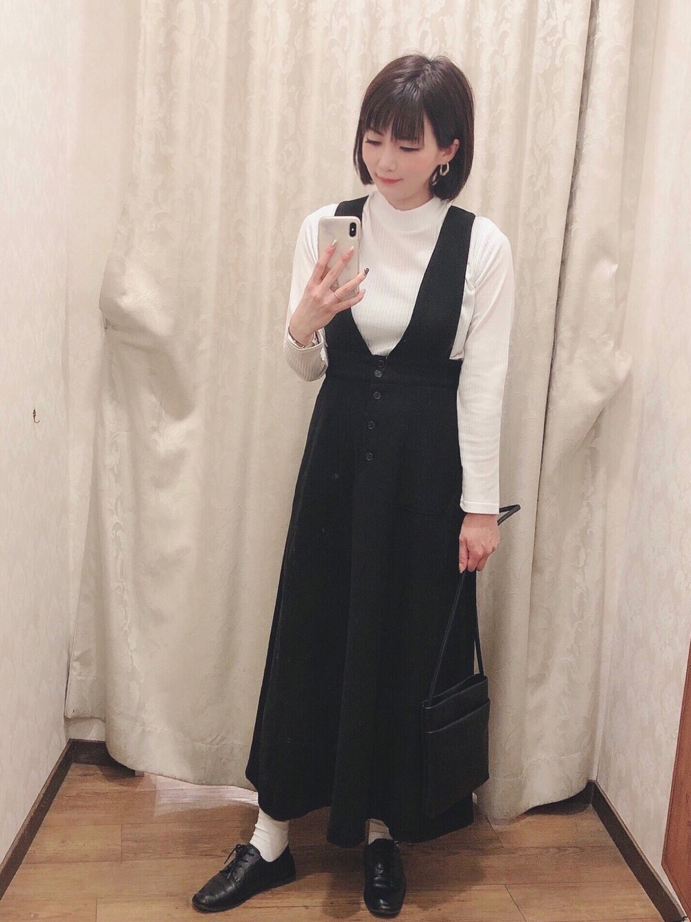 ブラック系のスカート、ホワイト系のTシャツ/カットソー、ブラック系のその他シューズを着用したレディースの冬コーディネートの1枚目の写真
