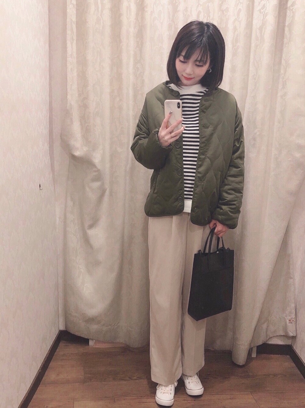 ブラック系のTシャツ/カットソー、グリーン系のブルゾン、ホワイト系のスニーカーを着用したレディースの冬コーディネートの1枚目の写真