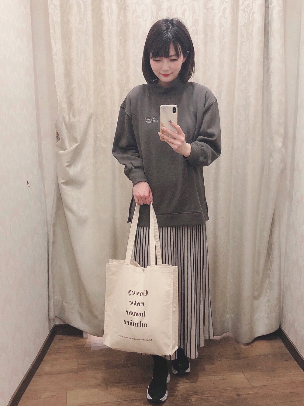 グレー系のスウェット、ホワイト系のトートバッグ、ブラック系のブーツを着用したレディースの冬コーディネートの1枚目の写真