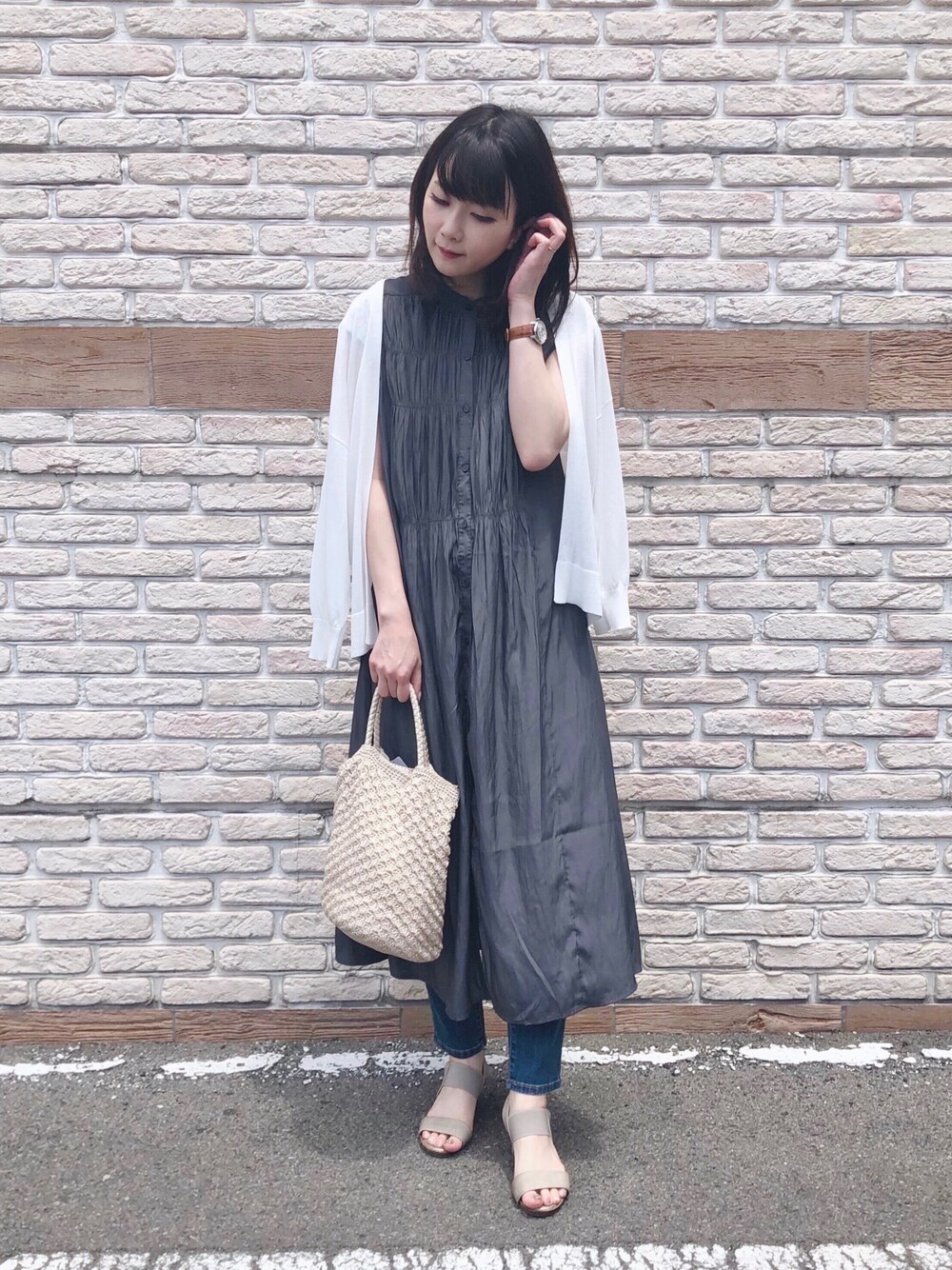 グレー系のワンピース、ホワイト系のカーディガン/ボレロ、ベージュ系のサンダルを着用したレディースの夏コーディネートの1枚目の写真