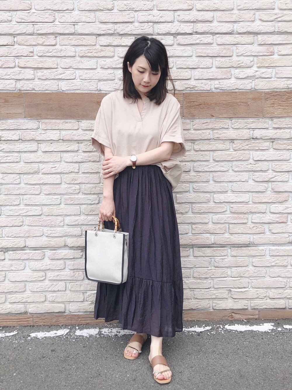 ベージュ系のシャツ/ブラウス、ブラック系のスカート、ブラウン系のサンダルを着用したレディースの夏コーディネートの1枚目の写真
