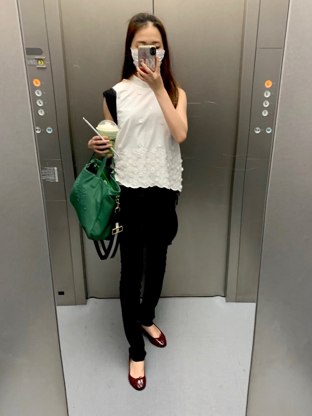 ブラック系のパンツ、ブラウン系のバレエシューズ、グリーン系のトートバッグを着用したレディースの夏コーディネートの1枚目の写真