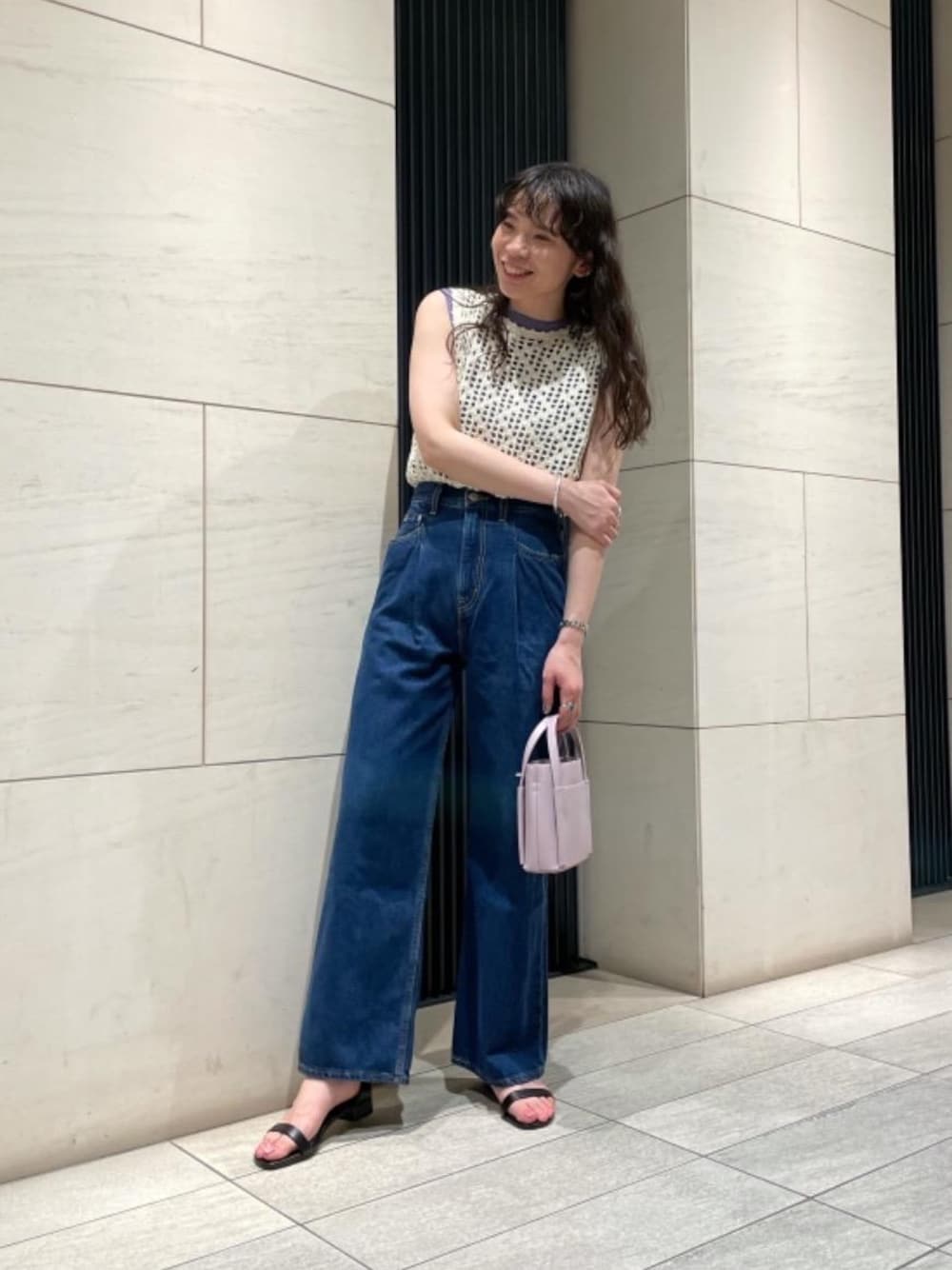 パープル系のショルダーバッグ、ブルー系のデニムパンツ、ホワイト系のニット/セーターを着用したレディースの夏コーディネートの1枚目の写真