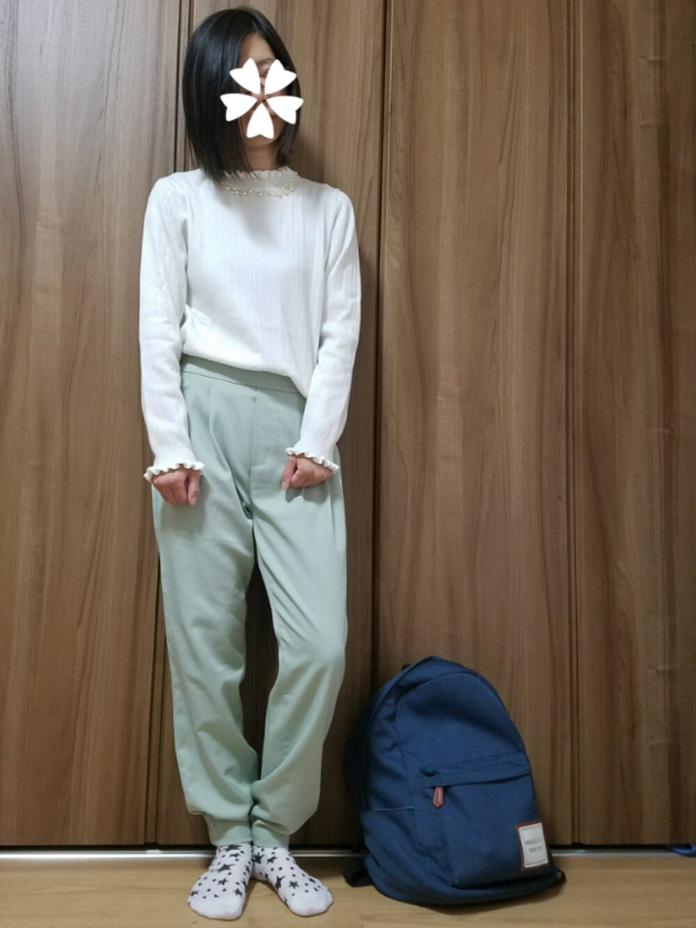 ホワイト系のトップス、グリーン系のパンツ、ブルー系のバックパック/リュックを着用したレディースの春コーディネートの1枚目の写真