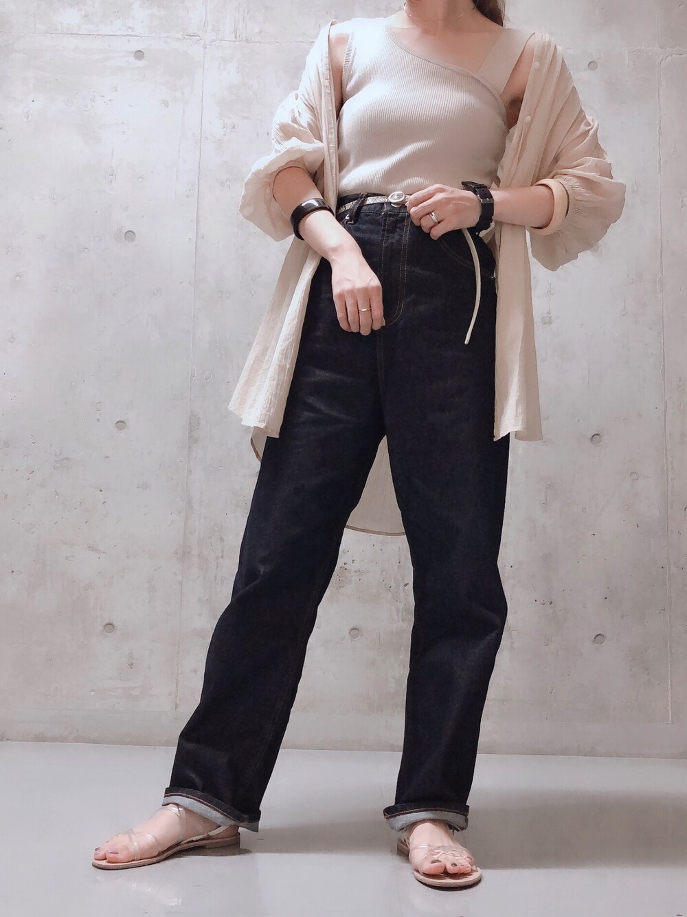 ベージュ系のシャツ/ブラウス、ベージュ系のニット/セーター、ブルー系のデニムパンツを着用したレディースの夏コーディネートの1枚目の写真