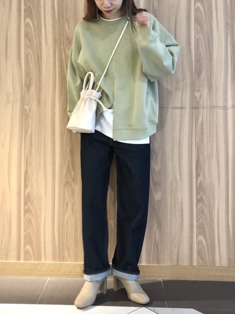 グリーン系のトップス、ホワイト系のTシャツ/カットソー、ブルー系のデニムパンツを着用したレディースの冬コーディネートの1枚目の写真