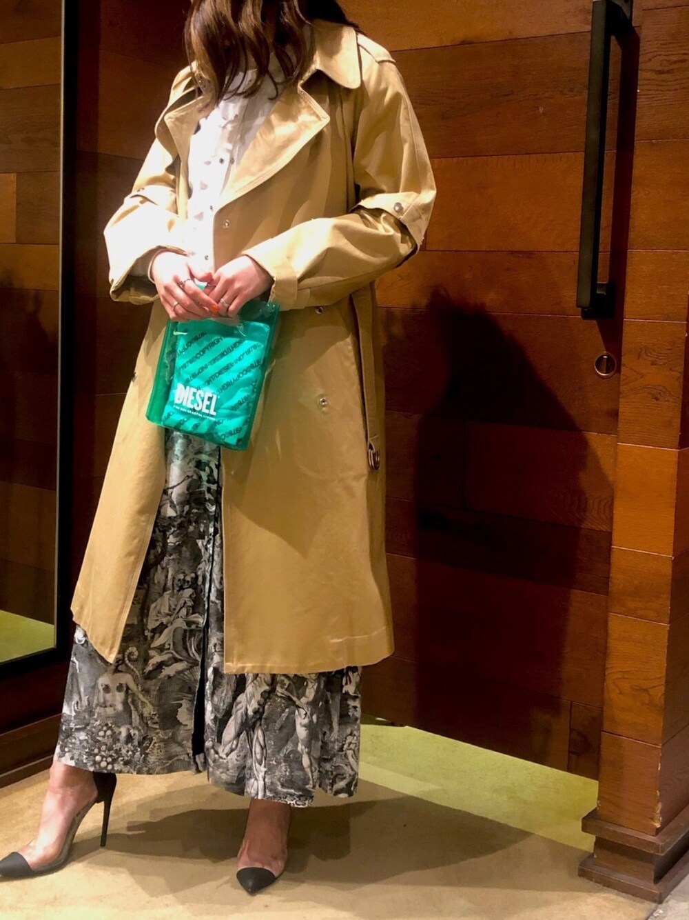 ベージュ系のトレンチコート、グレー系のスカート、ブラック系のパンプスを着用したレディースの春コーディネートの1枚目の写真