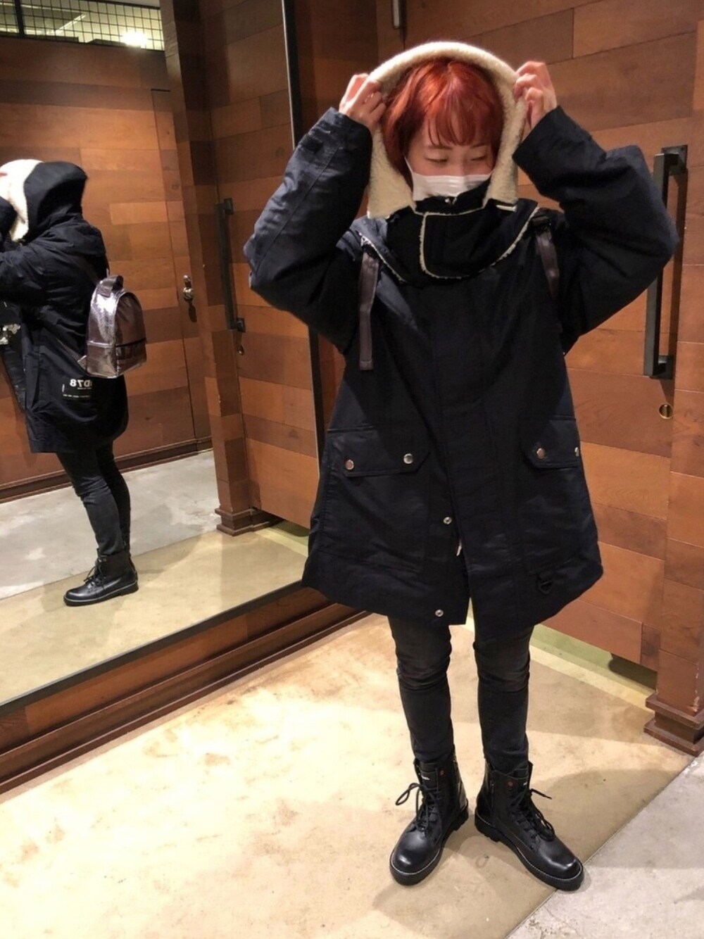 ブラック系のミリタリージャケット、ブラック系のデニムパンツ、ブラック系のブーツを着用したレディースの秋コーディネートの1枚目の写真